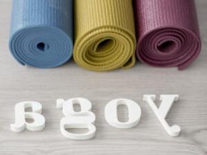 3 rolled up yoga mats and the word yoga